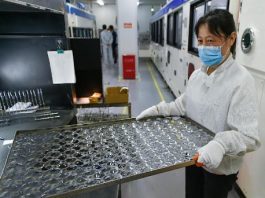 A worker works in an optical lens factory in Danyang, east China's Jiangsu province. (Photo by Fang Dongxu/People's Daily Online)